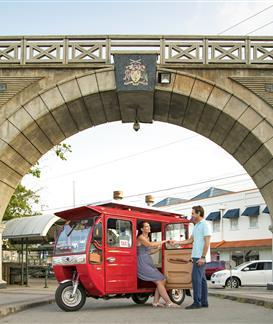 Barbados charm with vibrant street life and architecture Arch bridge in Barbados with people and a red tuk-tuk