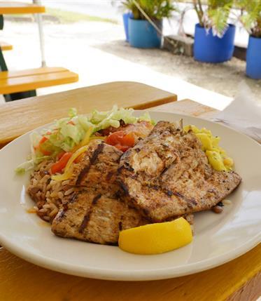 Barbados Culinary Delights Plate of grilled fish with salad and rice at a restaurant