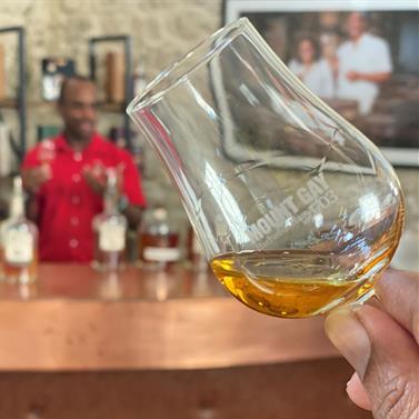 Barbados Spirits Tasting Experience Person holding a glass of drink with a bartender in the background