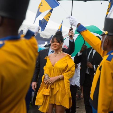 Barbados Cultural Scene with Flags and Participants Person in yellow at a cultural event surrounded by flags