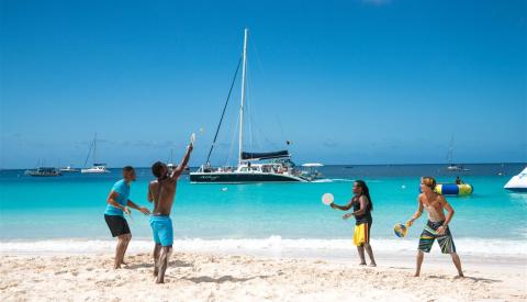 Barbados Beach Fun with Paddleball and Boats People playing beach paddleball with boats in Barbados
