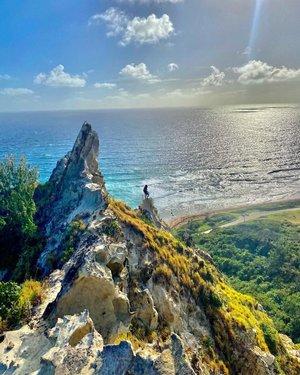 Barbados: Awe-Inspiring Coastal View with a Lone Observer Stunning coastal landscape of Barbados with a person standing on a cliff