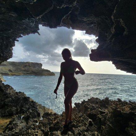 Barbados Adventure: Coastal Cave Exploration Person exploring coastal cave in Barbados