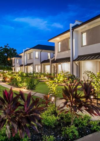 This image shows a row of modern two-story houses at dusk