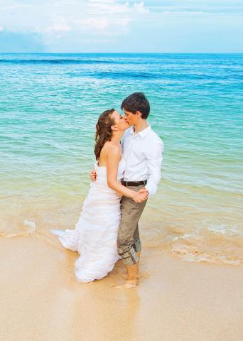 The image captures a romantic moment between a couple on a beach