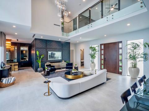 This image showcases a modern, spacious living room with high ceilings and a contemporary design
