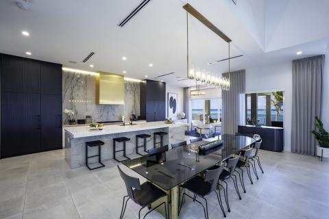 This image displays a modern and stylish kitchen and dining area inside a luxurious home