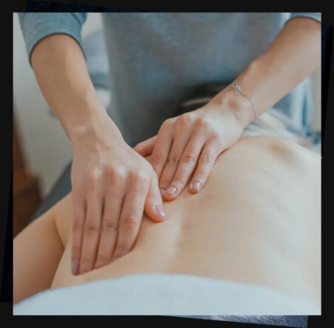 This image shows a person giving a back massage to another individual