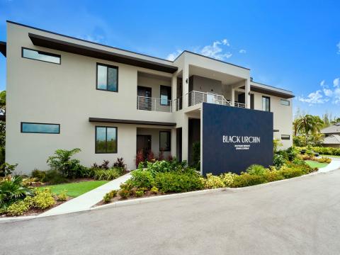 The image shows a modern two-story building with a sleek, contemporary design