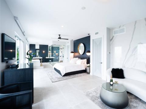 This image shows a modern, luxurious bedroom suite with an open plan design