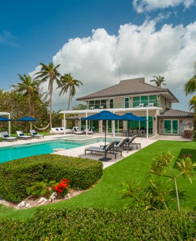 The image features a luxurious house with a large outdoor swimming pool