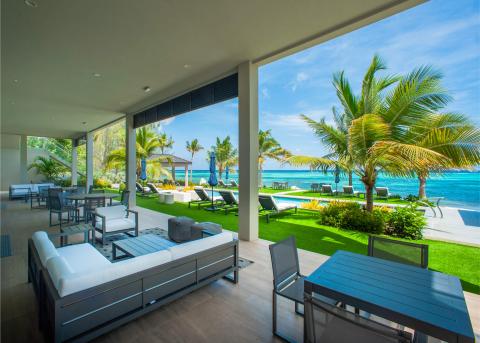 This image showcases a luxurious outdoor lounge area adjacent to a modern indoor living space