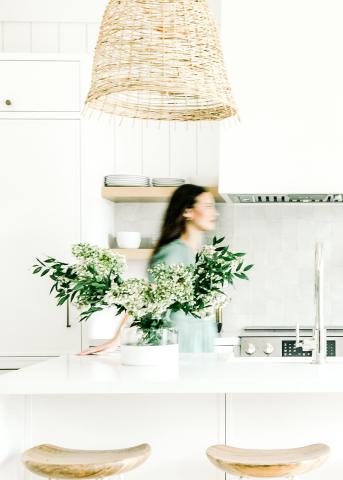 This image shows a modern kitchen interior featuring bright, clean aesthetics with white cabinetry and a grey tile backsplash