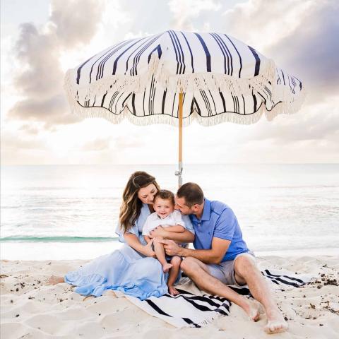 The image depicts a happy family moment on a beach