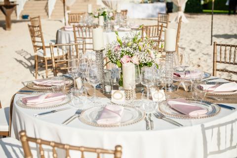 This is an image of an elegantly set outdoor dining area, likely for a special event such as a wedding or a formal gathering