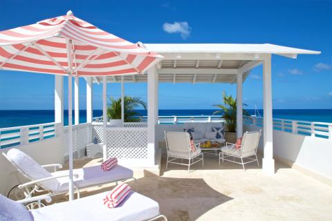 The image depicts a luxurious beachfront patio