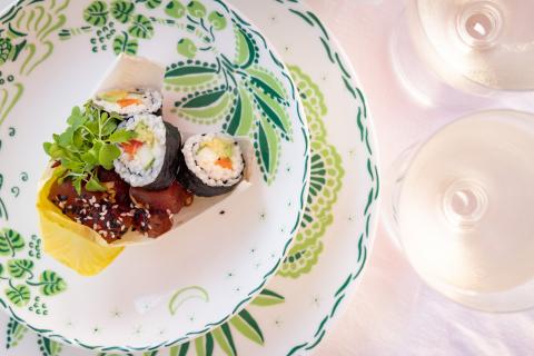 This image features a gourmet dish consisting of sushi rolls and sashimi