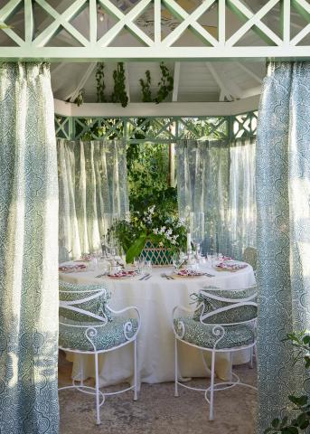 This image shows an elegantly set outdoor dining area within a gazebo