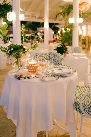 This image shows a beautifully set dining area in an elegant outdoor setting, possibly at a resort or open-air restaurant