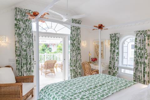 The image depicts a bright and airy tropical-style bedroom