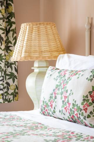 This image features a cozy bedroom corner consisting of a bed and a nightstand