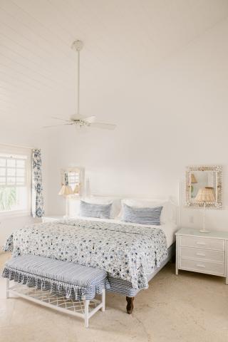 This image features a well-lit and spacious bedroom with a fresh, clean aesthetic