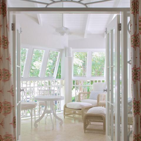 This image shows the interior of a bright and airy sunroom or closed veranda