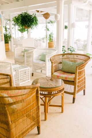 This image features an elegant indoor terrace or patio area decorated with natural light and bright, airy colors
