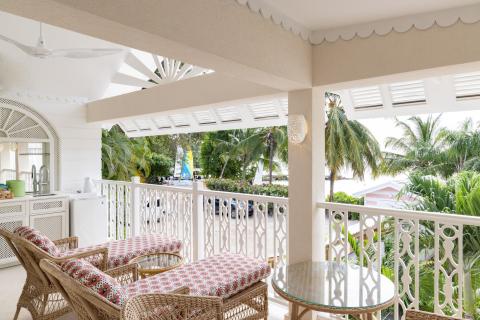 This image features a view from a balcony or covered patio area of a beachfront property