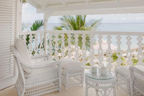 This is a relaxing, picturesque balcony scene overlooking a beautiful beach