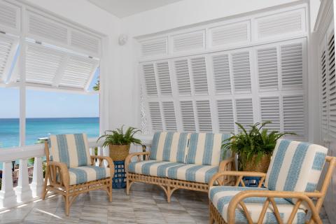This image shows a cozy, beachfront balcony setting