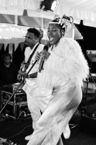This image captures a dynamic and expressive moment of a live music performance under a tent