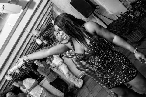 The image shows a lively scene at what seems to be a party or social gathering, shot in black and white