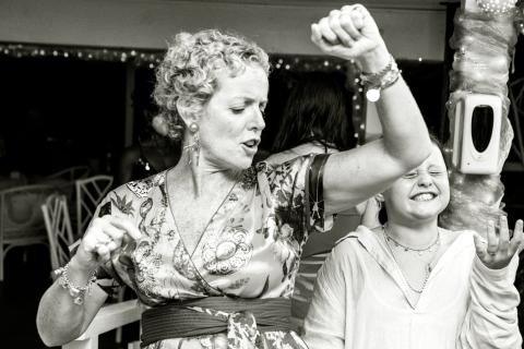 The image shows two people, likely at a festive event, engaged in a joyful dance