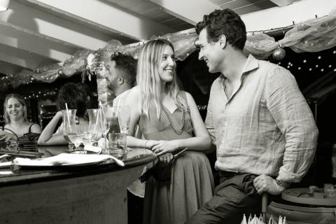 This black and white image captures a social scene at a bar or a party