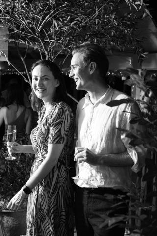 This is a black and white image showing a man and a woman at what appears to be a social gathering