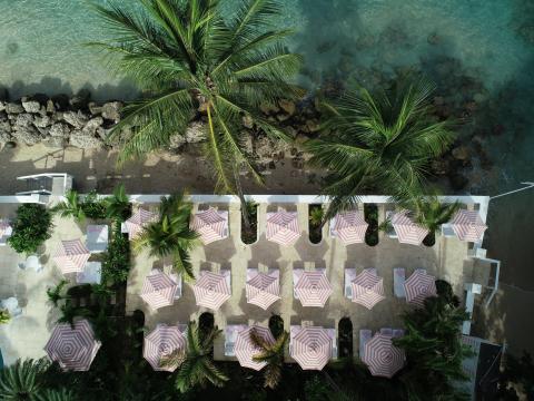 This image features an aerial view of a coastal outdoor seating area