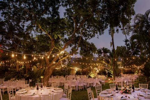 This image showcases a beautifully set outdoor event space, likely prepared for an evening celebration or gathering