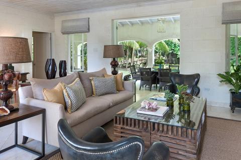 This image displays an elegantly designed living room that seamlessly transitions to an outdoor area