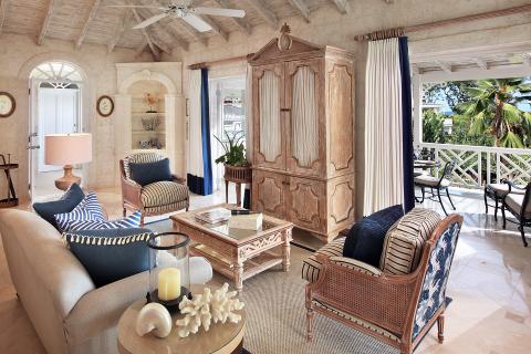 The image shows a tastefully decorated living room with a tropical coastal theme