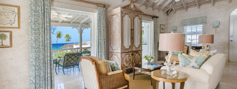This image depicts a beautifully decorated coastal living room, offering a splendid view of the ocean
