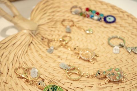 The image displays a collection of various jewelry items arranged on a woven straw mat