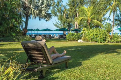 The image shows a serene beachside setting, likely at a tropical resort