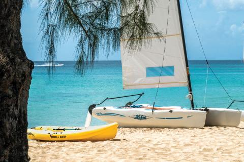 This image portrays a serene beach scene with clear blue waters and white sand