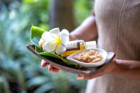 This image features a person holding a tray with various spa products