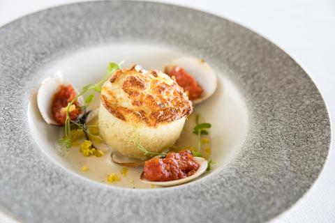 The image shows an elegantly plated gourmet dish on a textured grey plate