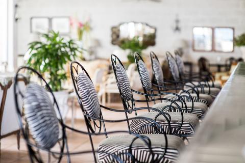 This image showcases a stylish indoor dining area featuring a long table adorned with multiple decorative chairs