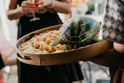 This image shows a creatively presented fruit platter in a wooden round tray