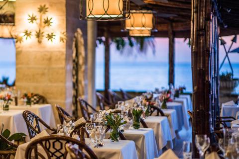 This image shows a beautifully arranged dining area, likely of a beachside restaurant