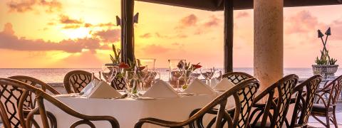 This image shows a beautifully arranged outdoor dining setting at sunset